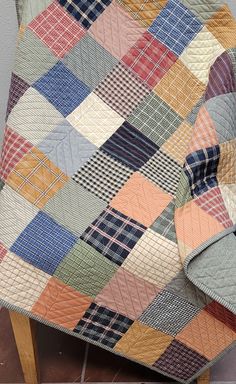 a patchwork quilt sitting on top of a wooden chair