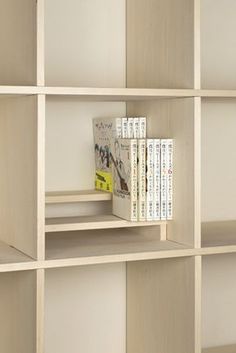 a book shelf with several books on it in front of a wall full of shelves