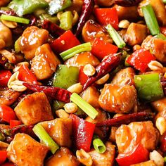 chicken and peppers stir fry in a wok with sesame seeds on the side, ready to be eaten