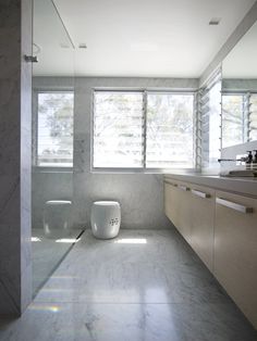 a bathroom with two urinals in it next to a window