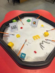 an ice tray with letters and magnets on it in the shape of a circle