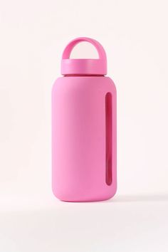 a pink water bottle sitting on top of a white table