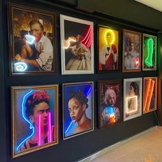 a wall that has some pictures on it with neon lights hanging from the side of it