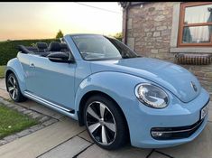 a blue convertible car parked in front of a house