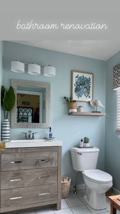 a bathroom with blue walls and white tile on the floor, including a wooden cabinet