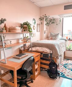 a room with a bed, desk and shelves filled with plants on the wall next to a window