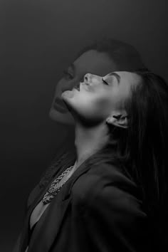 a woman with long hair and piercings is looking up at the sky in black and white