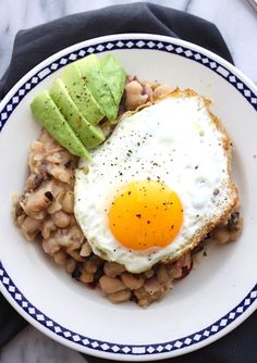 an egg is on top of beans and avocado