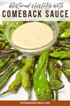 some green peppers on a white plate with a small bowl of sauce in the middle