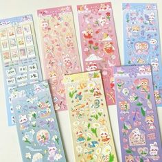 five different colored stickers with animals and flowers on them, all lined up next to each other