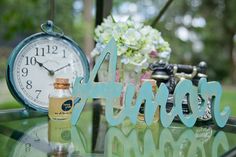 a glass table topped with a clock and bottles