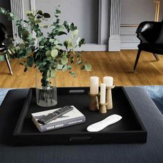 a tray with candles, remotes and flowers in it