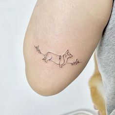 a woman's arm with a small tattoo of a fox on the left side