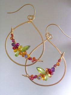 a pair of gold hoop earrings with colorful beads