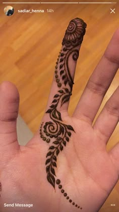 a hand with a henna on it that is in the shape of a flower