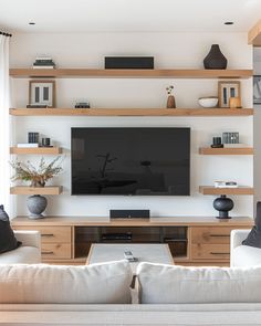 a living room filled with furniture and a flat screen tv mounted on a wall next to a window