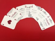 four playing cards are arranged in the shape of an arch on a red background with white writing