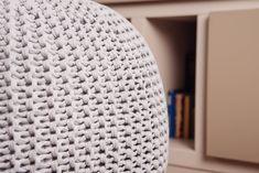 a close up view of the back of a chair with a bookcase in the background