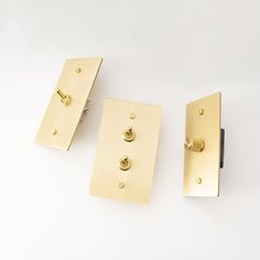 three brass door handles on a white surface