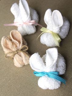 three small white towels with bows on them