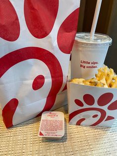 there is a paper bag with some food in it and a drink on the table