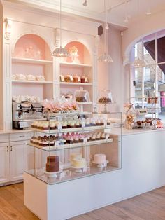 a display case filled with lots of cakes and cupcakes on top of glass shelves