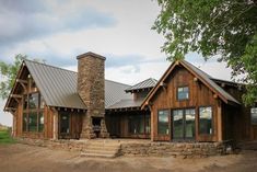 a large wooden house with a stone chimney