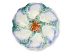 a blue and white plate with a star on it's center, in the shape of a flower