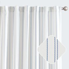 a white and blue striped curtain hanging on the side of a window