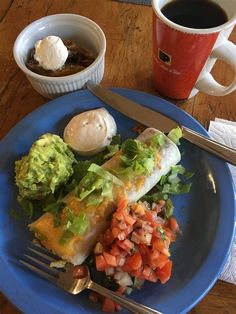 a blue plate topped with food next to a cup of coffee