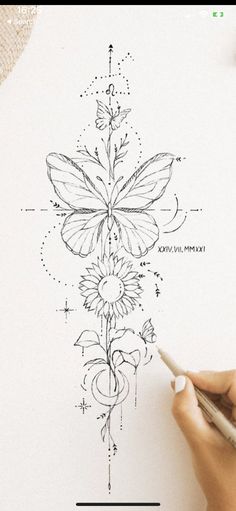 someone is drawing a flower on paper with a pen and inking it in the shape of a butterfly