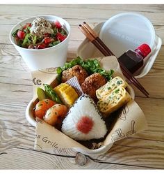 there are many different types of sushi in the bowl on the table with chopsticks