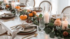 the table is set with candles, plates and napkins for an elegant thanksgiving dinner