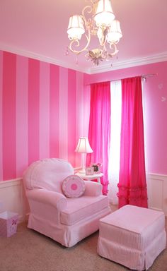 a pink and white striped room with a chandelier hanging from the ceiling over a chair