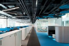 an empty office with blue carpeting and white cubicles on the walls is pictured in this image