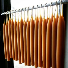 several hot dogs hanging from a rack in front of a window