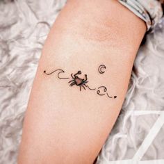 a small crab tattoo on the arm