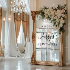 an ornate mirror with flowers on it in front of a chandelier and chairs