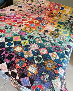 a bed with a colorful quilt on top of it