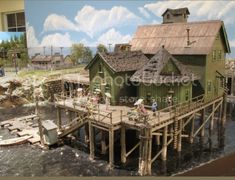 a model of a house on stilts in the water next to a boat dock