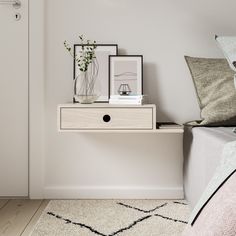 a bedroom with a bed, nightstand and pictures on the side table in front of it