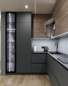 a modern kitchen with wooden floors and gray cabinets is seen in this image from the front view