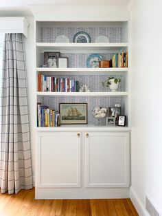 a white bookcase with books and pictures on it