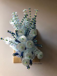 a bunch of white flowers sitting on top of a wooden stand next to a wall