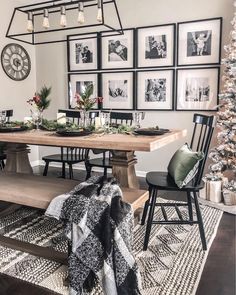 a dining room table with pictures on the wall above it and christmas decorations hanging from the ceiling