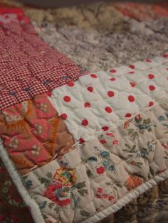 an old quilt with red and white flowers on it