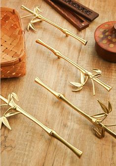 several different types of decorative items on a wooden table with gold colored handles and stems