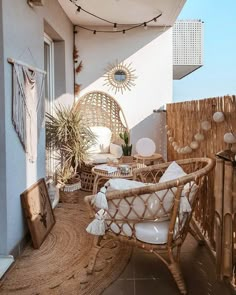 an outdoor patio with wicker furniture and hanging plants on the side of the building