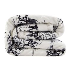 three folded blankets with black and white designs on them, one is folded up to the side