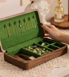 a wooden box filled with lots of different types of jewelry in it's compartments